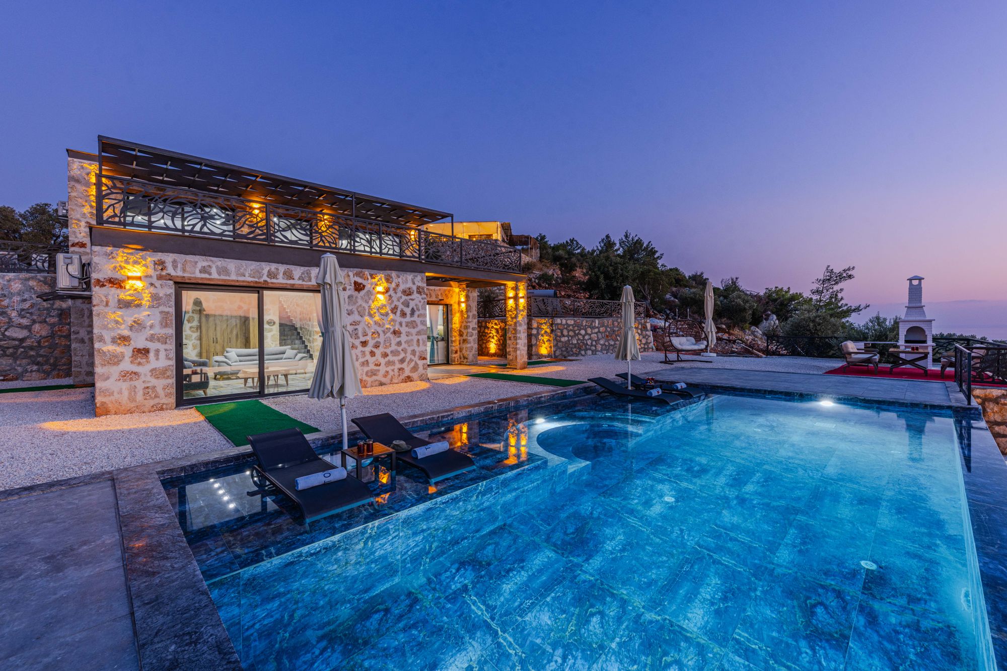 Villa de piedra con piscina al atardecer