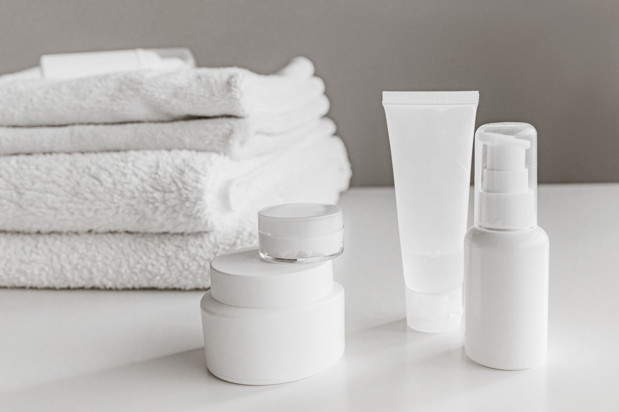 Productos de skincare y toallas blancas