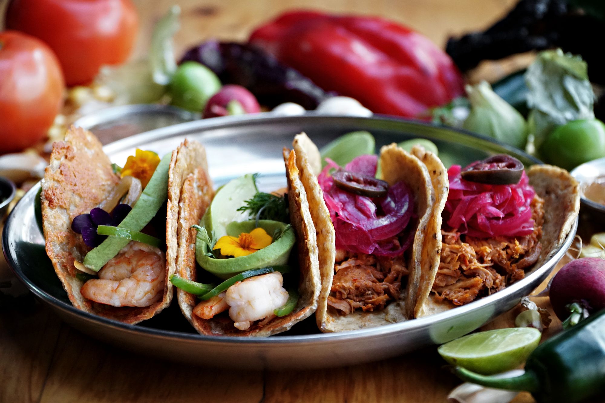Assorted tacos on a metal tray