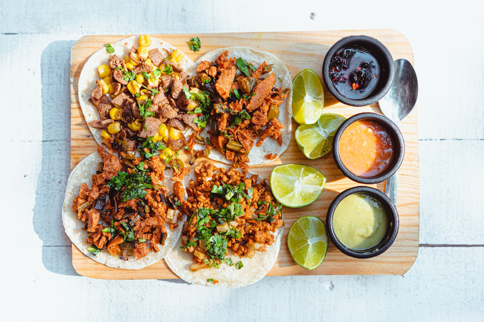 Tacos with salsas on a wooden board